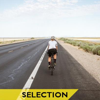 Cycliste femme sur une route traversant le désert